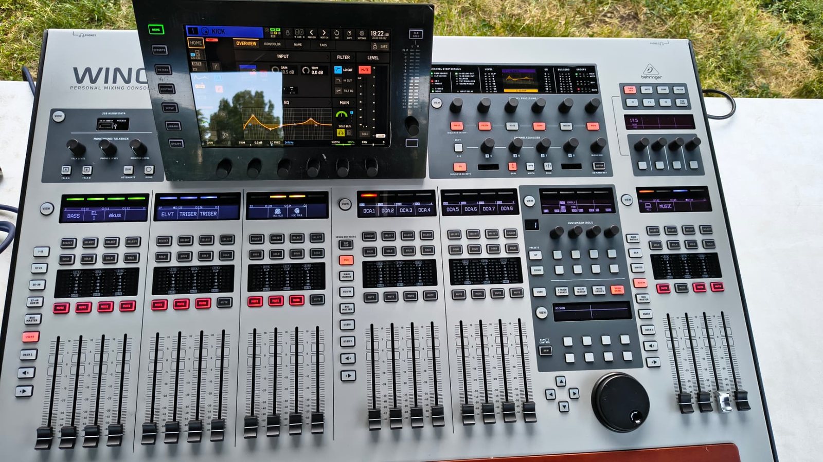 Digitální mixážní pult Behringer WING stojící venku na bílém podkladu